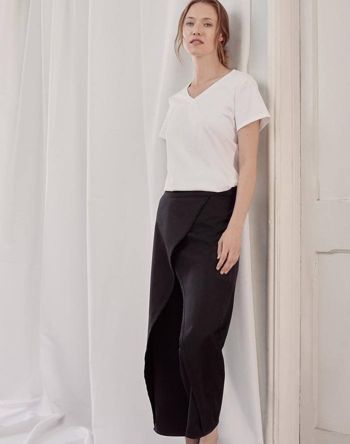 A person wearing a white shirt and black pants Description automatically generated with medium confidence