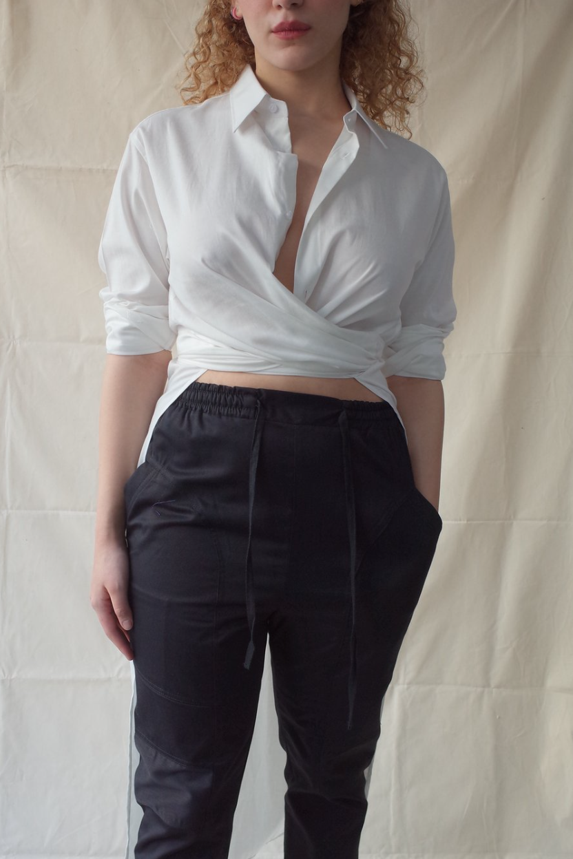 A person wearing a white shirt and black pants Description automatically generated with low confidence