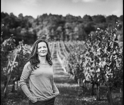 a person standing in front of a vineyard descript