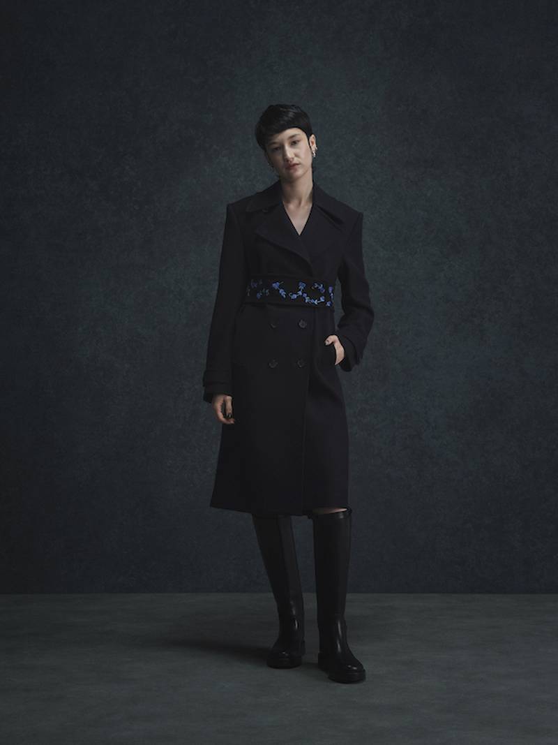 An outer coat is elevated with blue embroidery.
