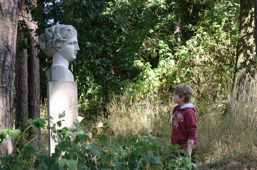A child standing next to a statue Description automatically generated with medium confidence