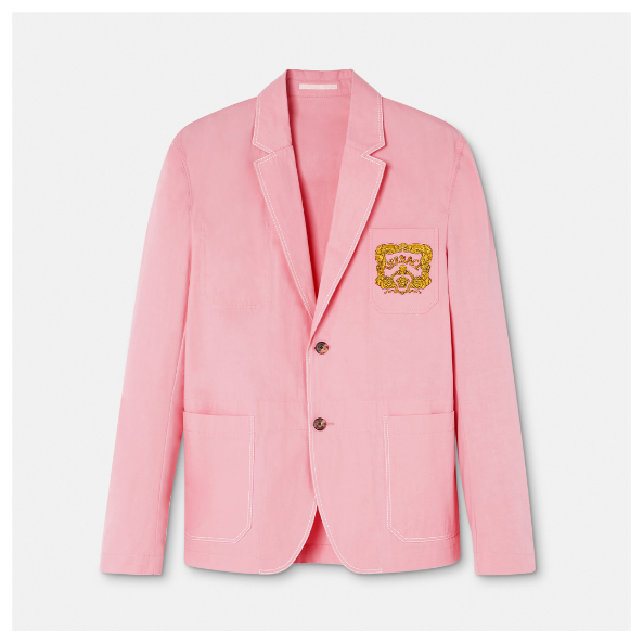 A pink blazer with a gold logo on it Description automatically generated