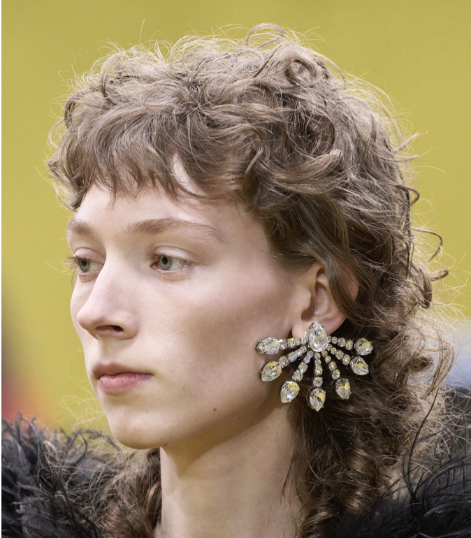 A person with a large earringDescription automatically generated