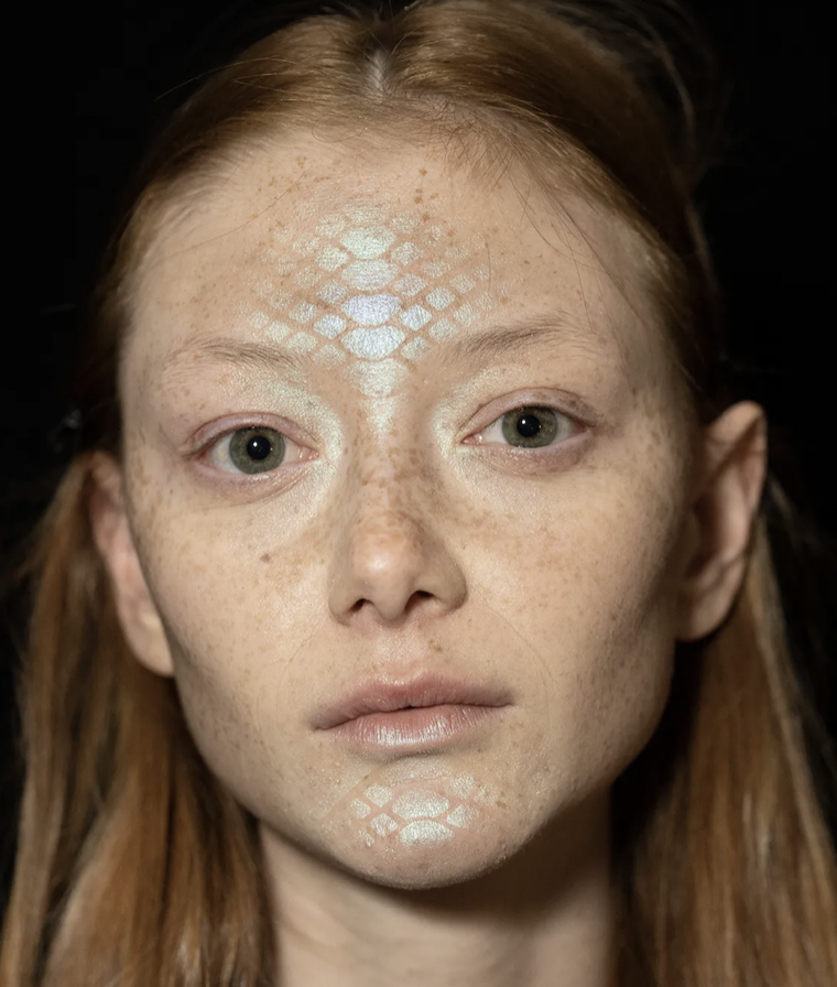 A person with a snake skin pattern on her faceDescription automatically generated