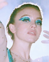 A person with glitter makeup Description automatically generated