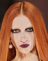 A person with red hair and makeup Description automatically generated