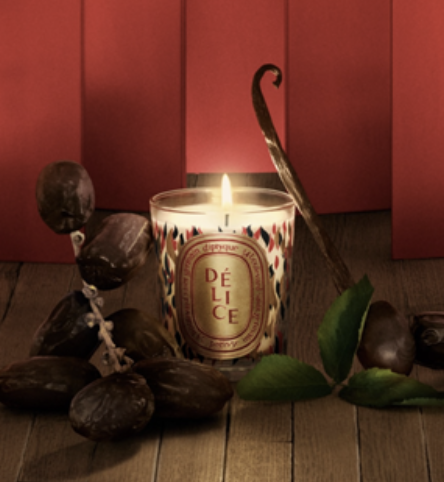 A candle and fruit on a table Description automatically generated