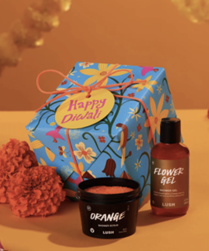 A gift box with a container and a small container with orange liquid Description automatically generated