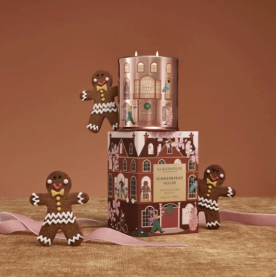 A gingerbread person and a candle on a stack of boxes

Description automatically generated