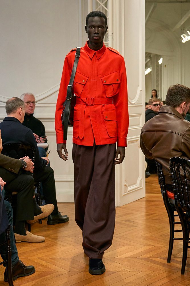 A mannequin wearing a red jacket and brown pants Description automatically generated