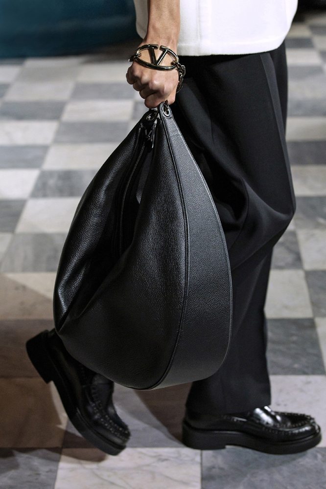 A person holding a black bag Description automatically generated