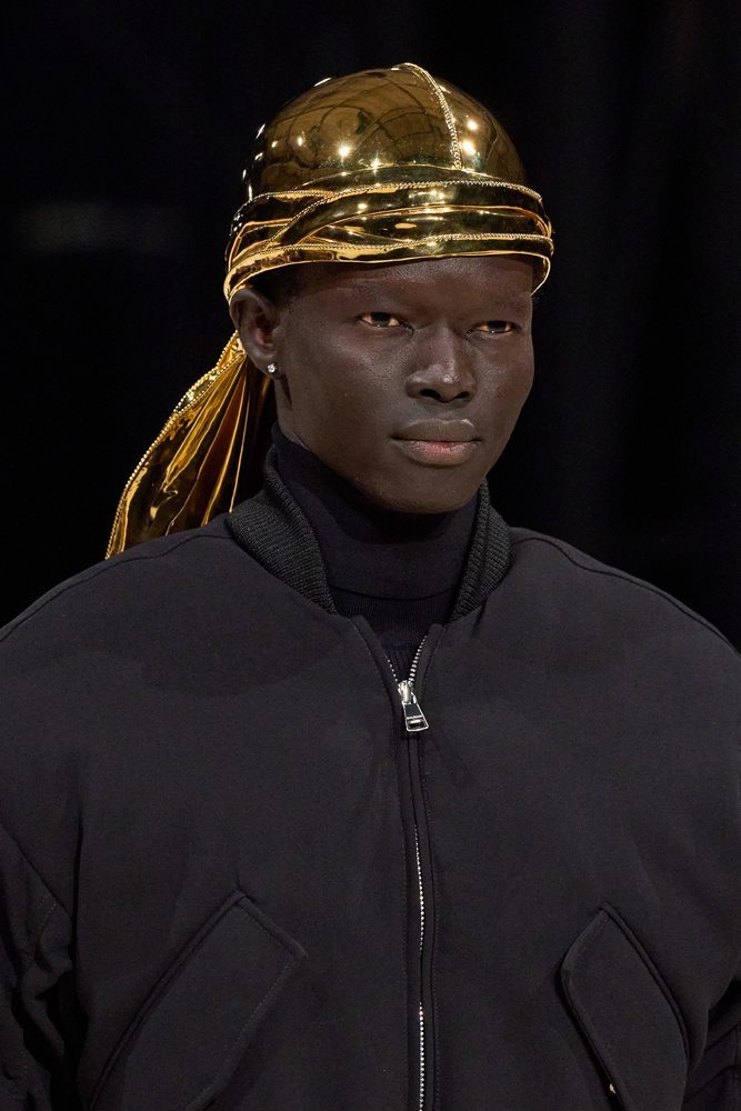 A person wearing a gold head wrap Description automatically generated