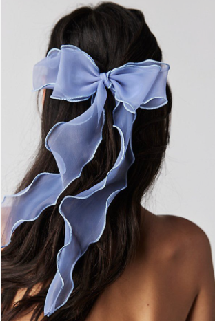 A person with a bow in her hair Description automatically generated