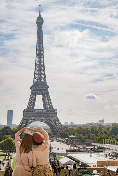 A couple standing in front of Eiffel Tower Navigating French Dating This Summer